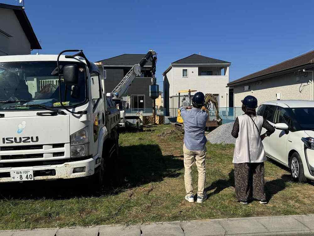 地盤改良工事でハイスピード工法による砕石パイルの施工を社長と設計スタッフが見守っている画像