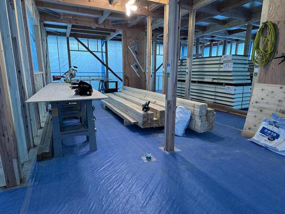 平屋住宅の木工事現場で、施工待ちのSWパネルや木材が整理して置かれている画像