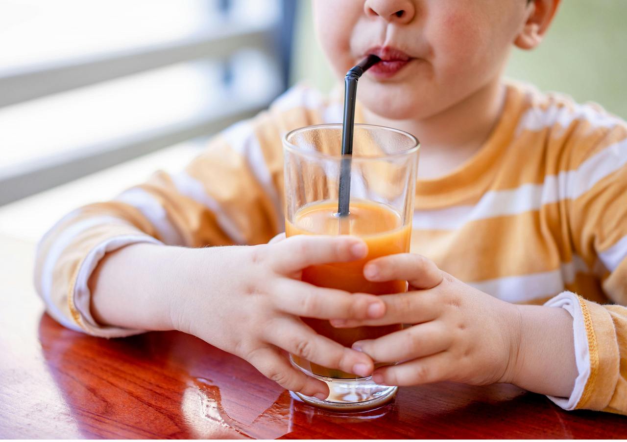 ストローでジュースを飲む子供の画像